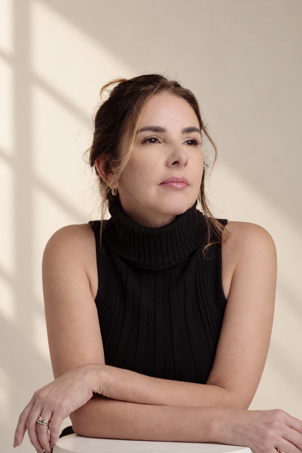 Anna Braga em olhar atento, de gola alta preta.